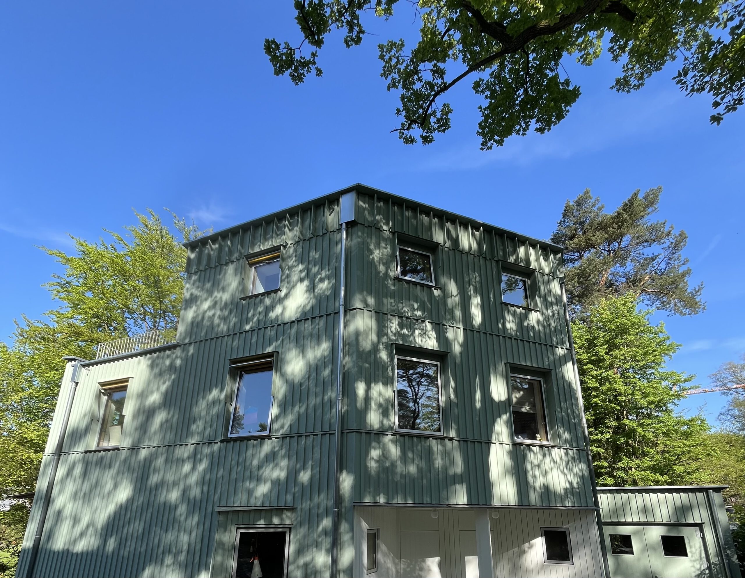 Neubau in Holzbauweise mit vertikaler Holzfassade, Ansicht über Eck