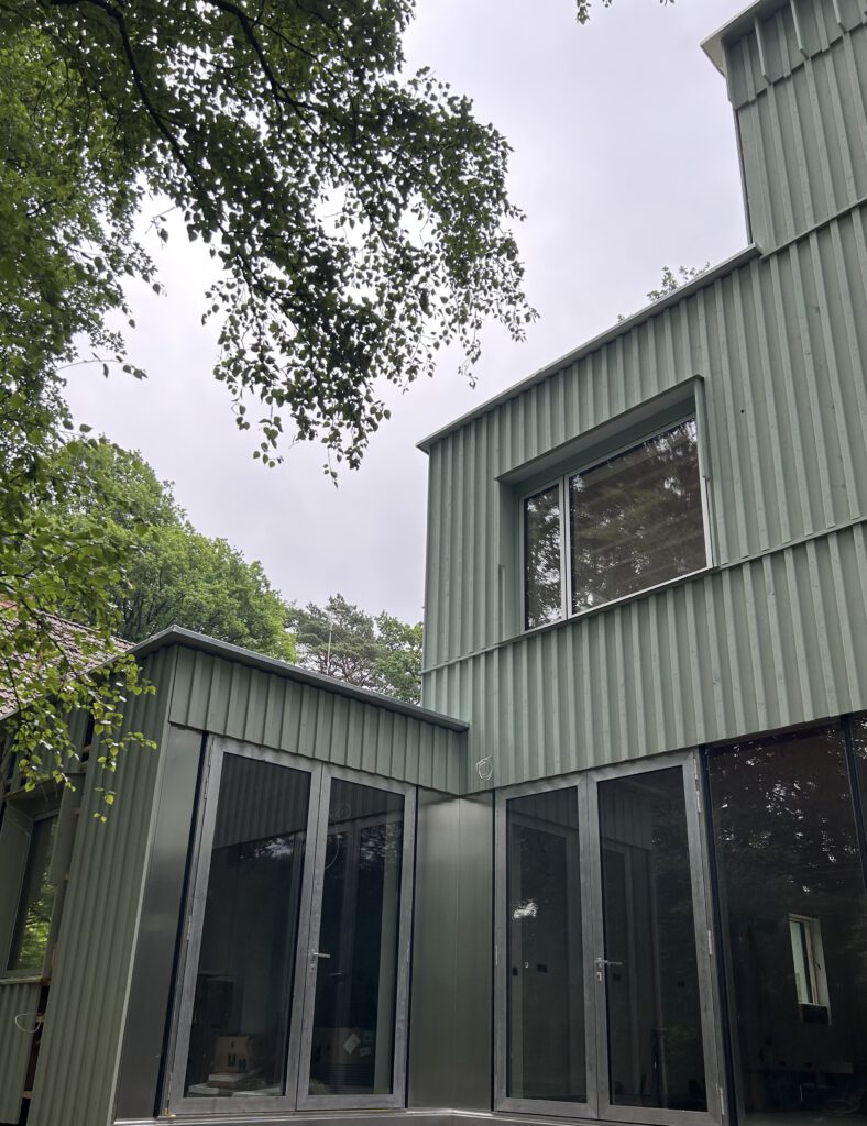 Gebäudeecke mit vertikaler Holzschalung und Fenster