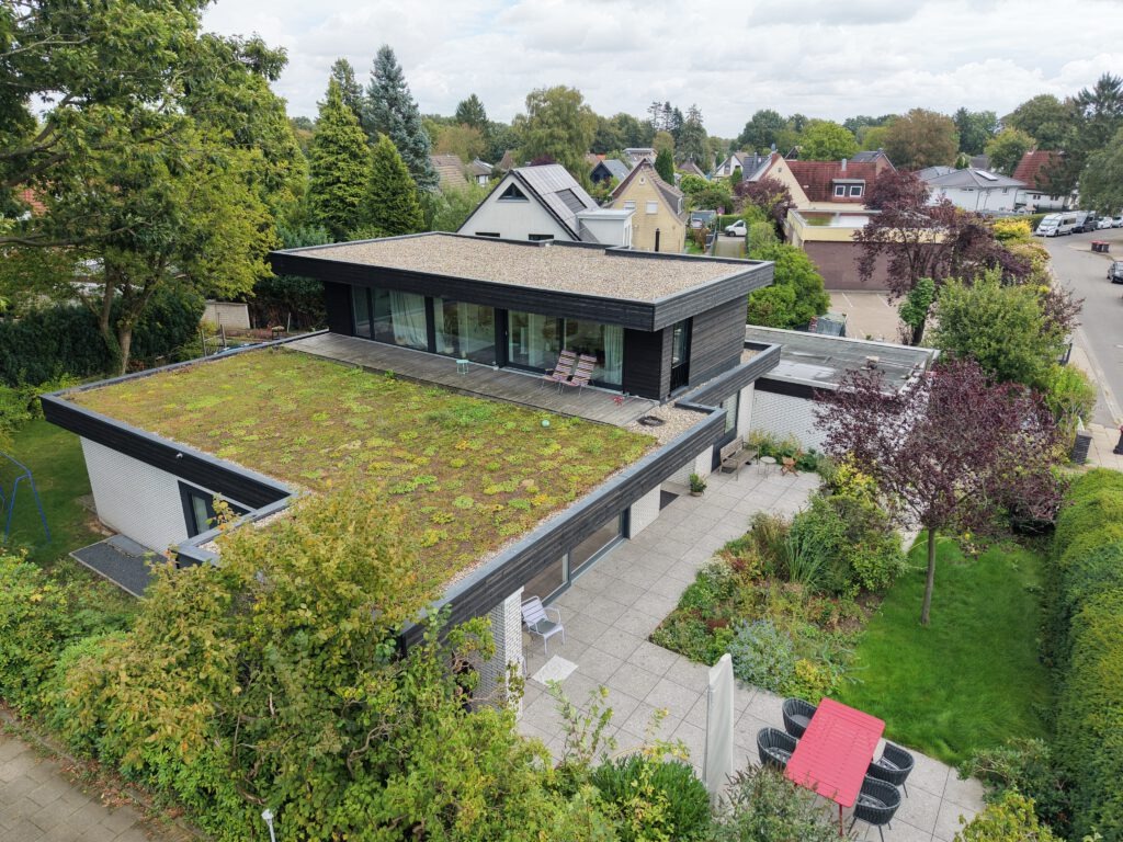Luftbild: Bungalow mit aufgesetztem Staffelgeschoss in Holzbauweise und Gründach in Lurup