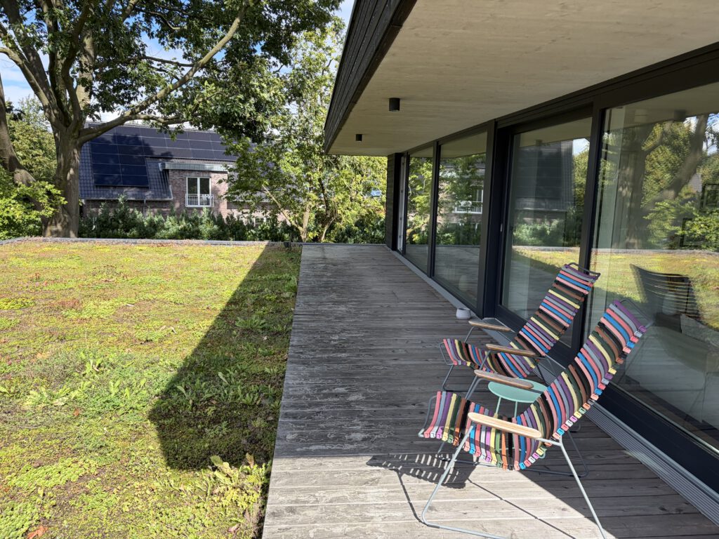 Überdachte Terrasse entlang der Glasfassade